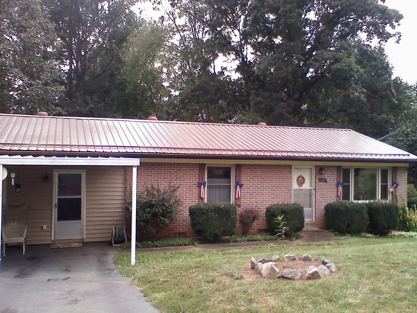 Bronze metal roof and carport on a brick ranch home — Roof Repair work by our crew in Cove